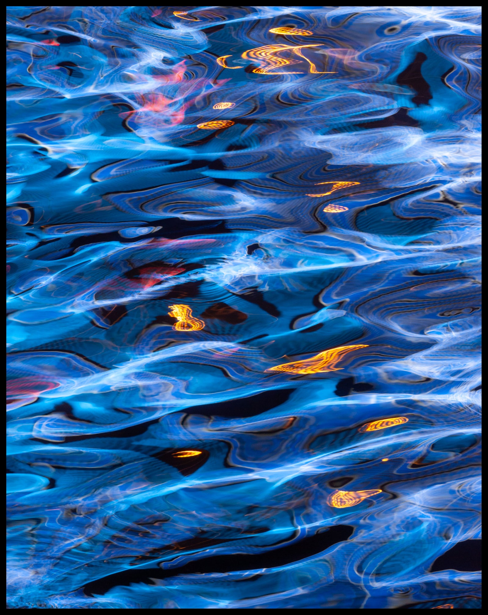 Abstract pattern of blue, orange, and black colors reflected in water